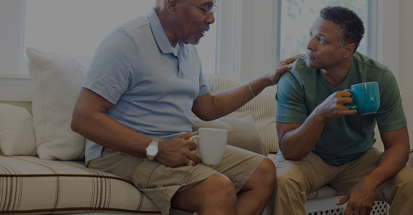 Father and son having coffee and talking about caregiver options for their family