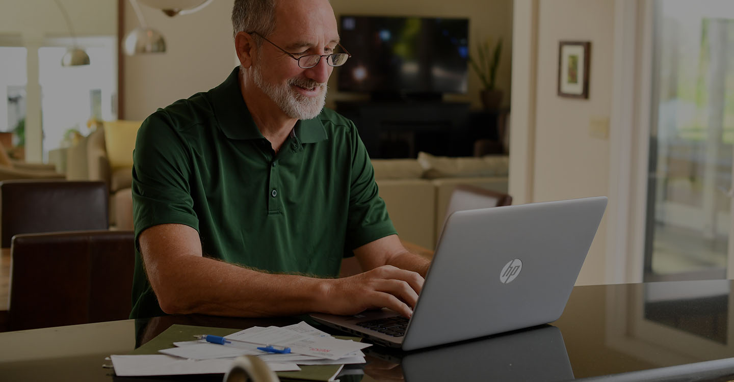 A man reviews additional diabetic health resources on his computer in a home office