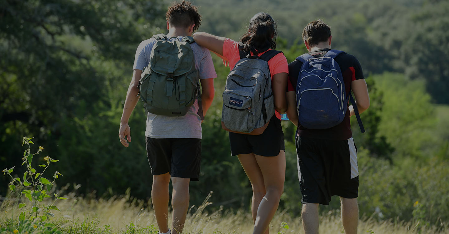 Three teens with pediatric diabetes walking outdoors in a field