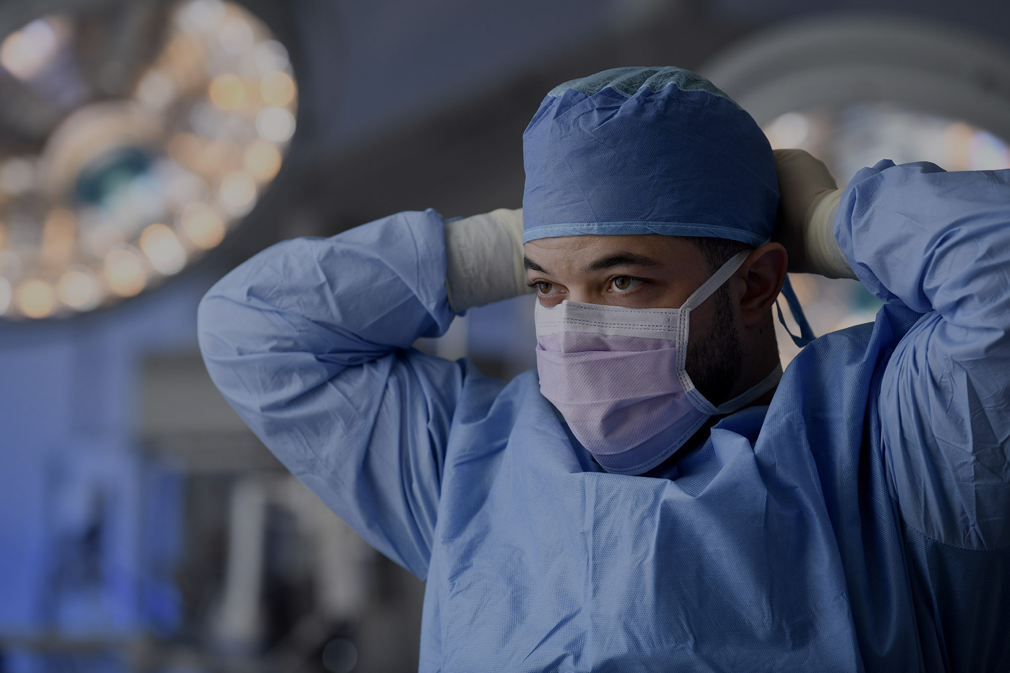 A surgeon putting on a mask.